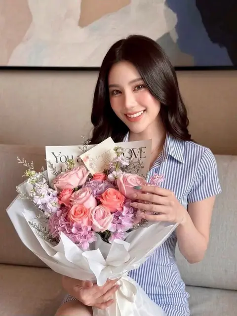 ลูกค้ายิ้มถือช่อดอกไม้โทนพาสเทล